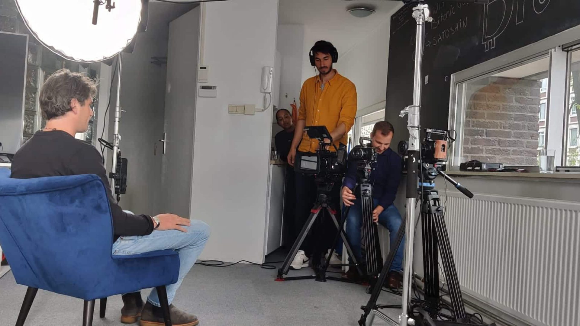 Interview setup with crew filming a professional interview indoors.