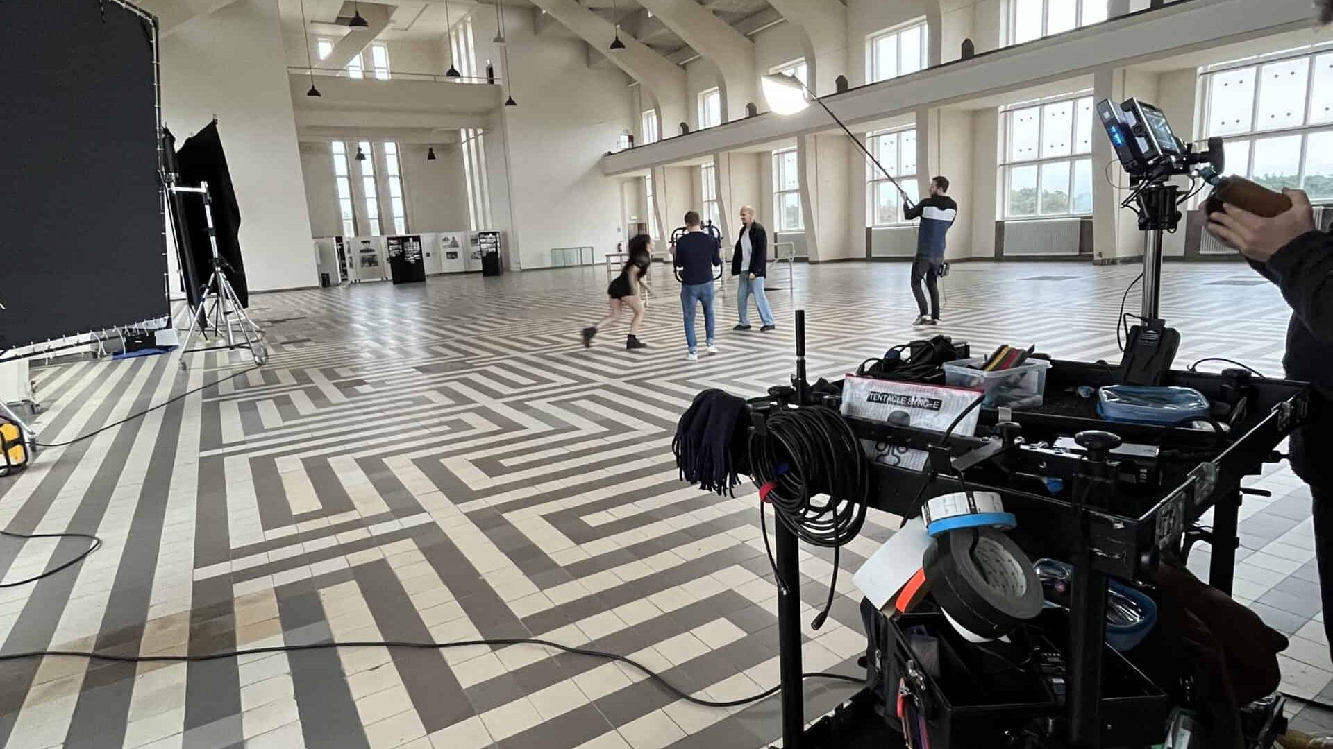 Professional video shoot in a large, well-lit studio with crew and equipment ready.