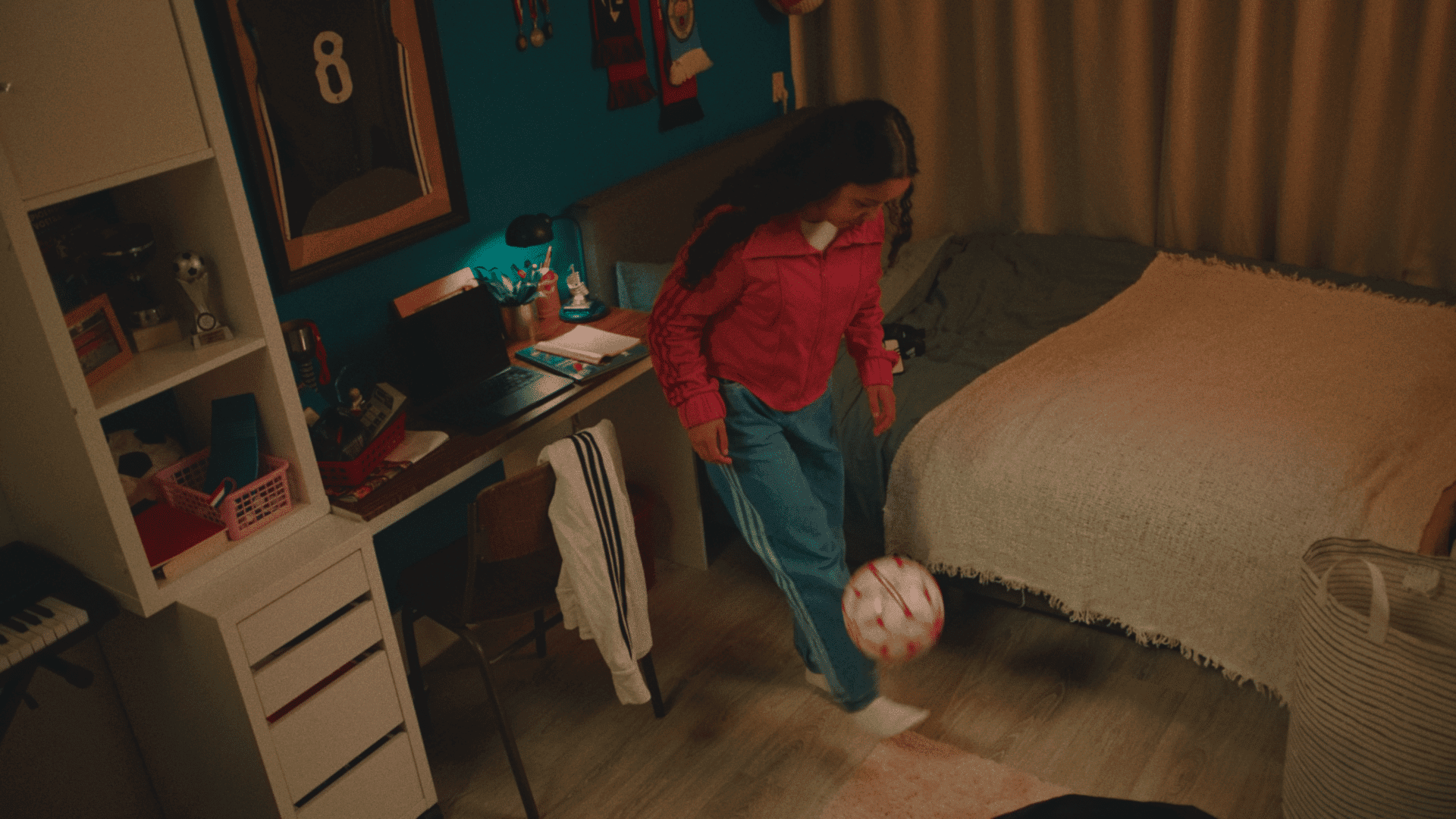 Girl playing with soccer ball in a cozy, creatively decorated room.