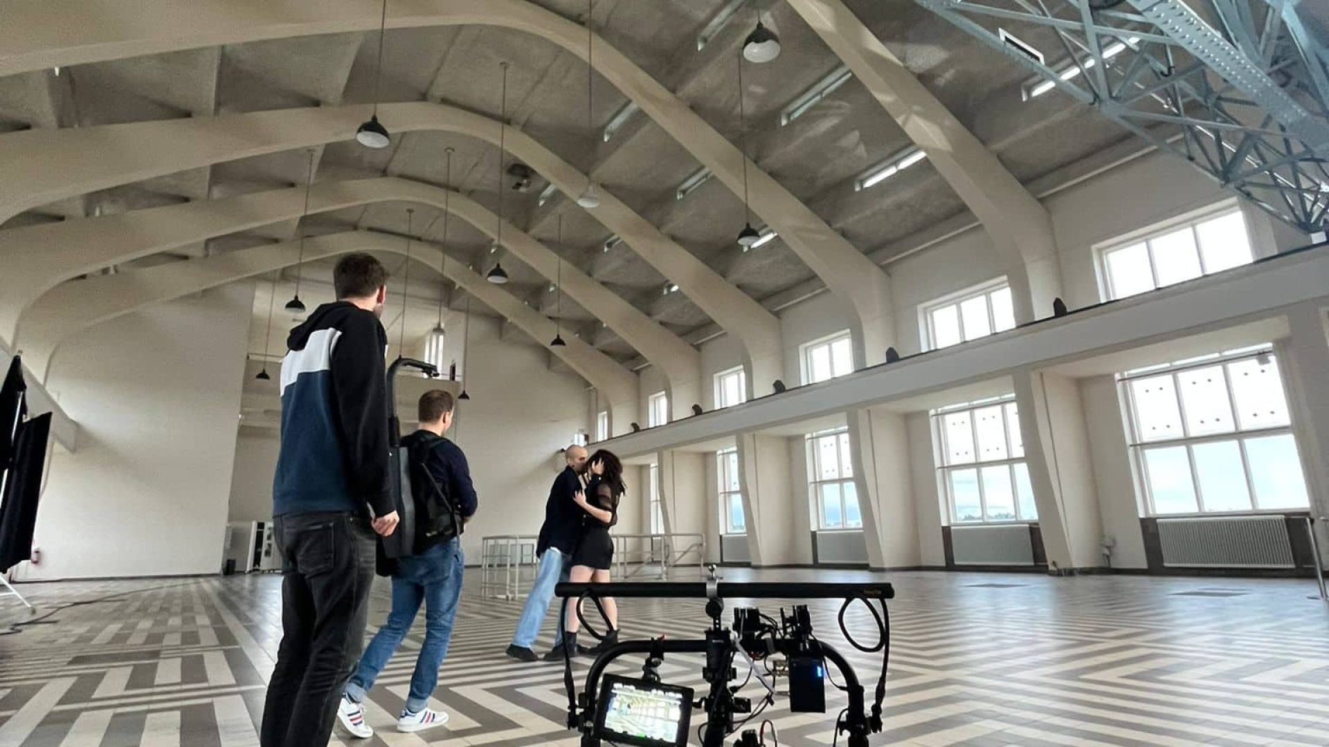 Interior of a spacious studio with a camera stabilizer and people preparing for filming.