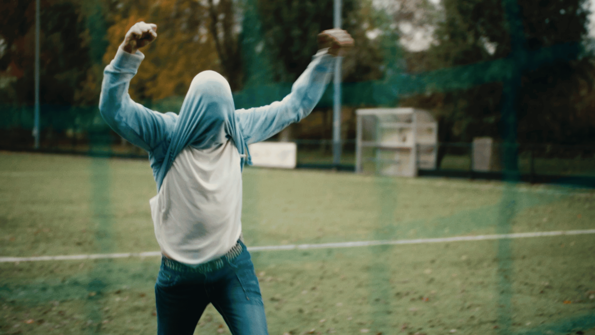 Person celebrating outdoors on a sports field, representing creativity and success.