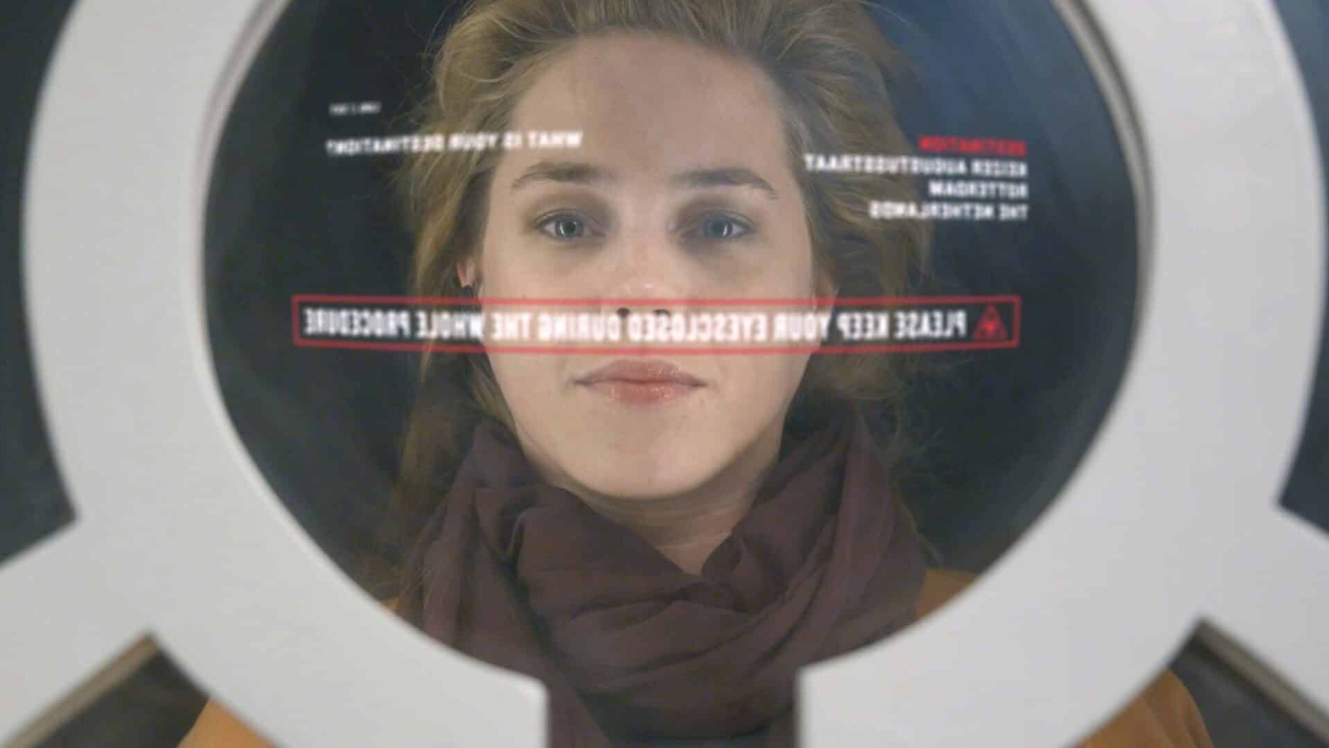 Female face seen through a camera lens with focus on her eyes.