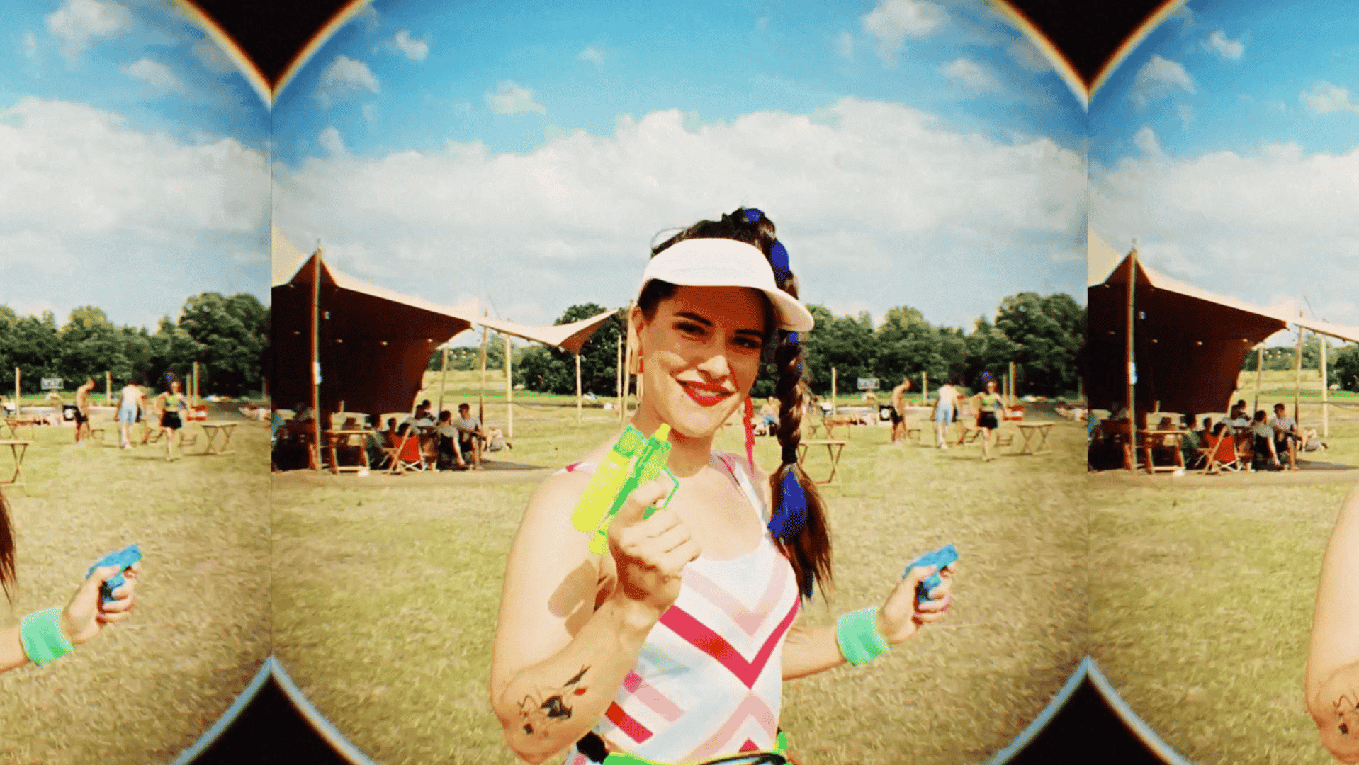 Woman at outdoor festival holding a green toy, smiling, with a sunny sky.