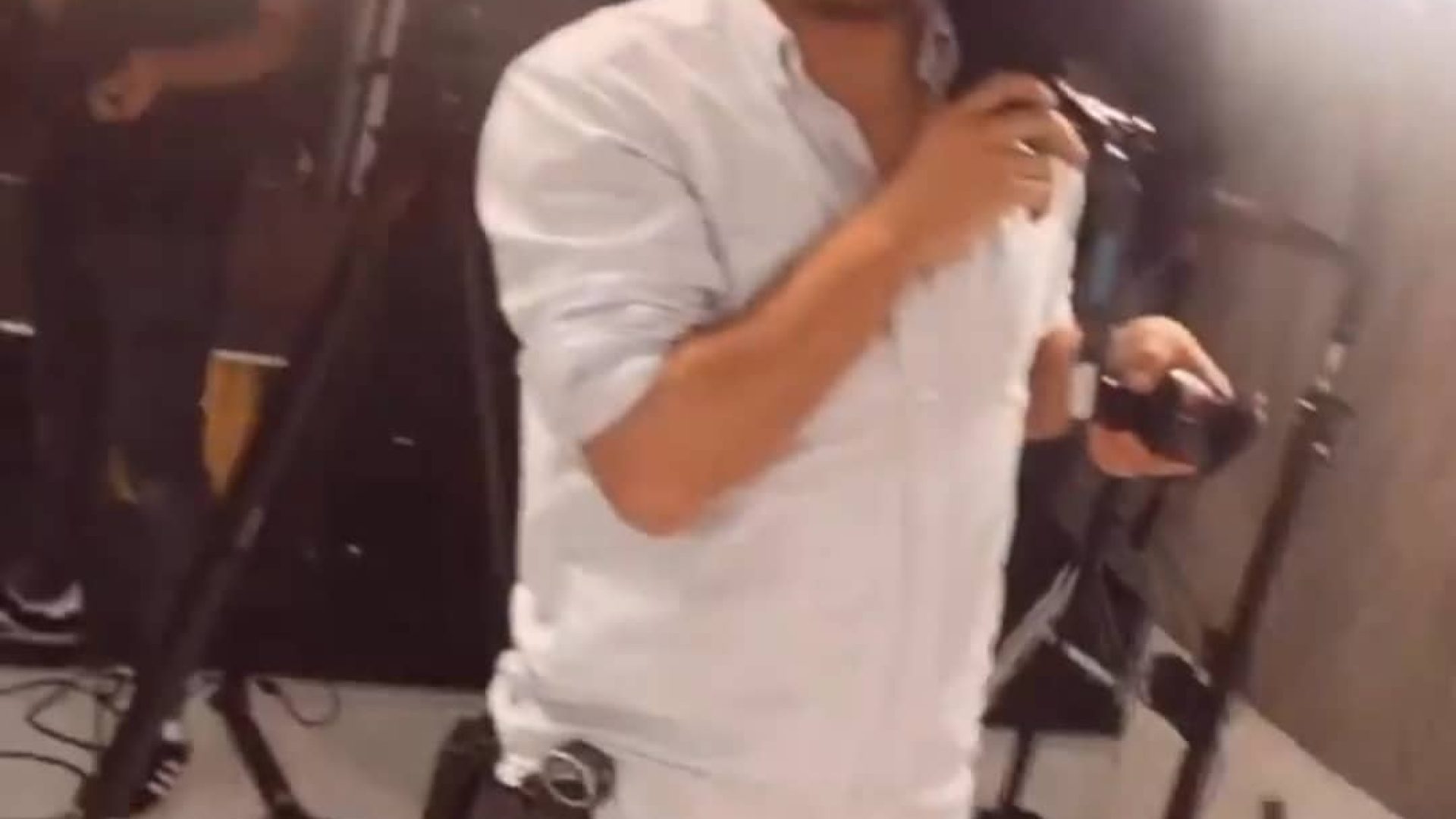 Behind-the-scenes shot of a videographer filming in a studio setting.