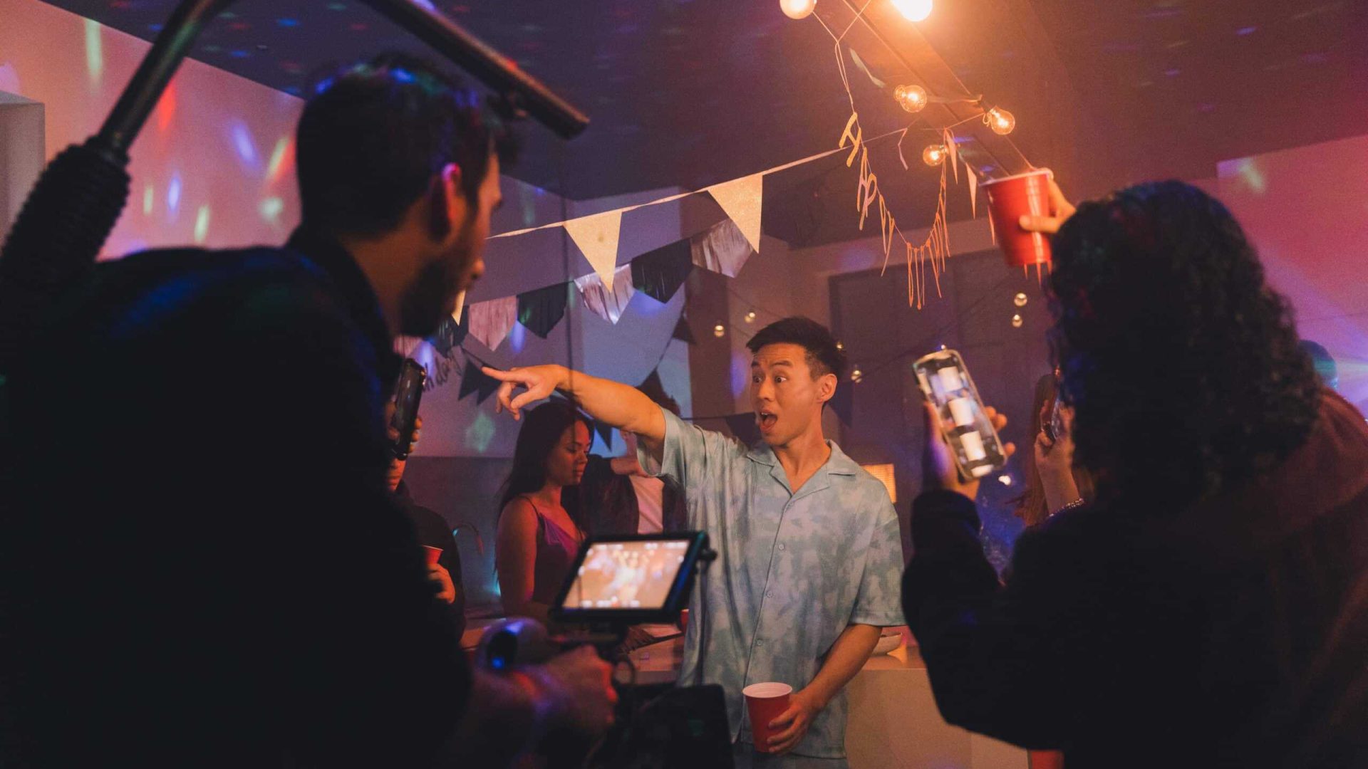 Creative video agency team filming at a lively party event.