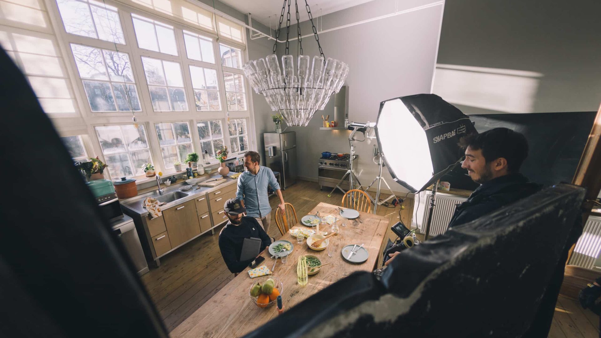 Filming a creative video in a well-lit kitchen with professional lighting equipment.