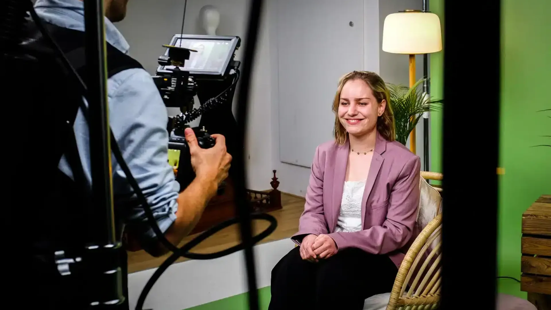 Woman being filmed for a professional video interview in a studio setting.