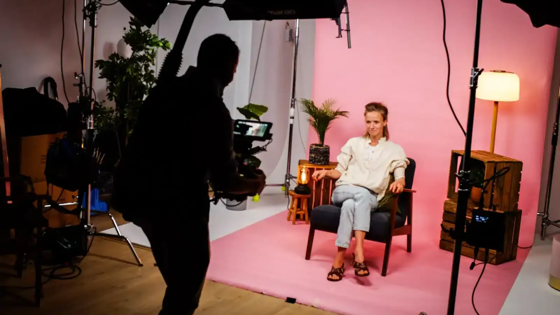 Professional video shoot with a woman seated in a studio setting.