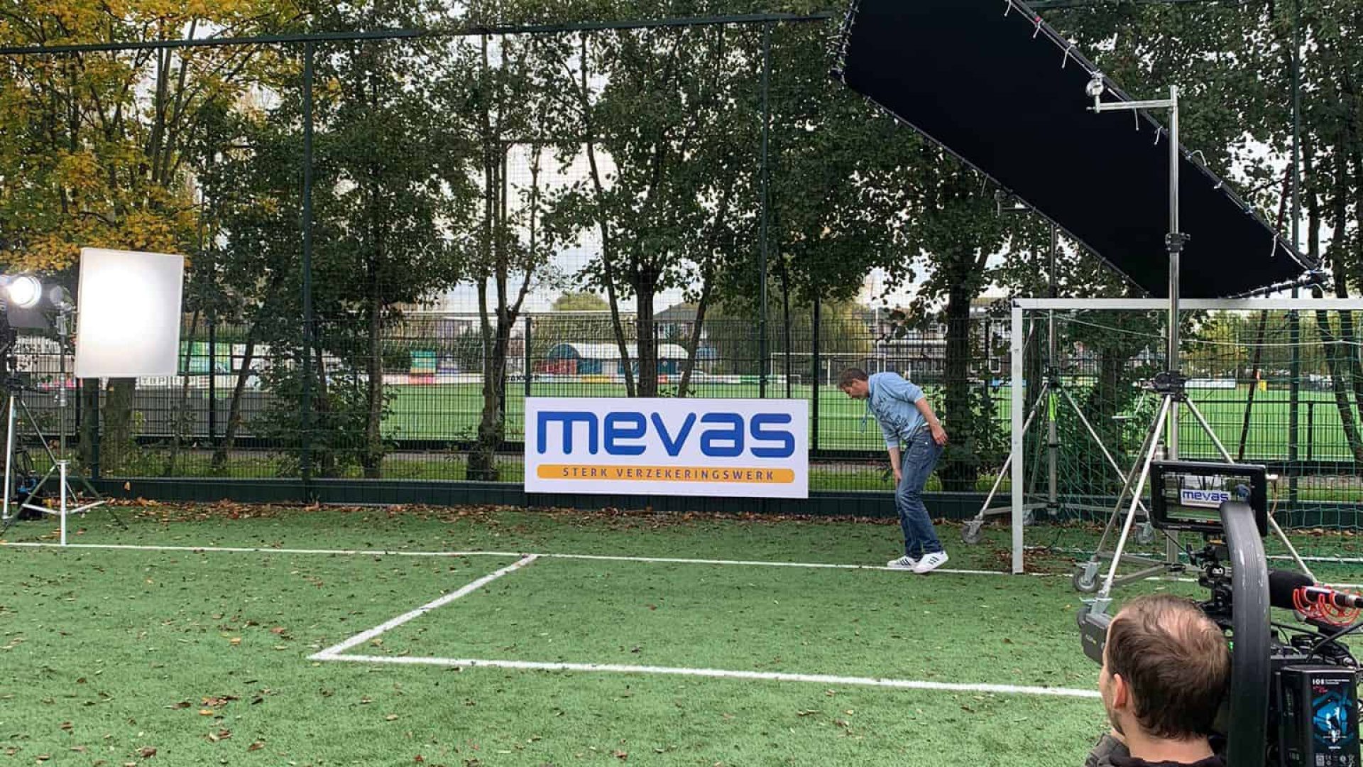 Outdoor filming setup with professional lighting and camera gear on a sports field for video product.